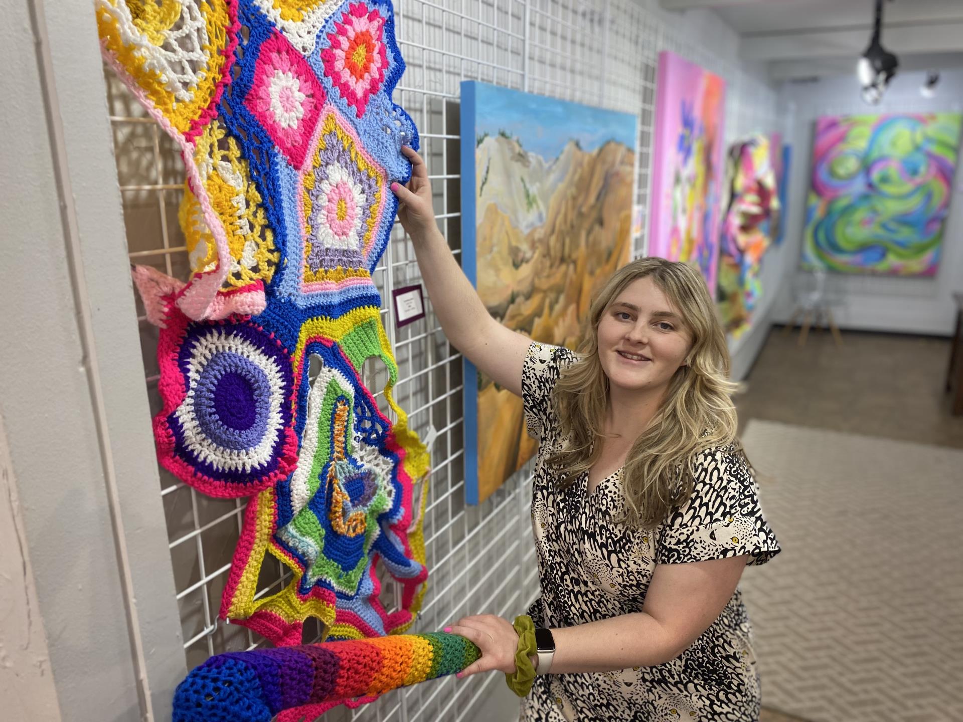 artist Chandler Wilson next to art display