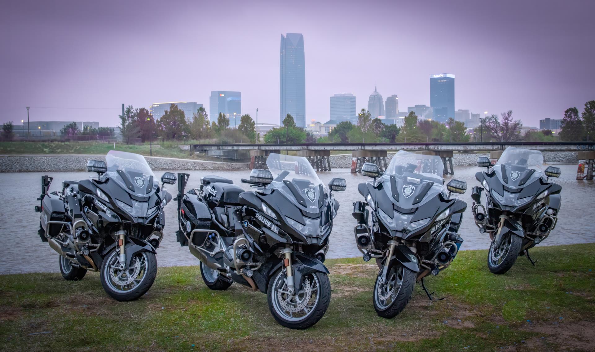 motocyles park along oklahoma river with skyline in the back