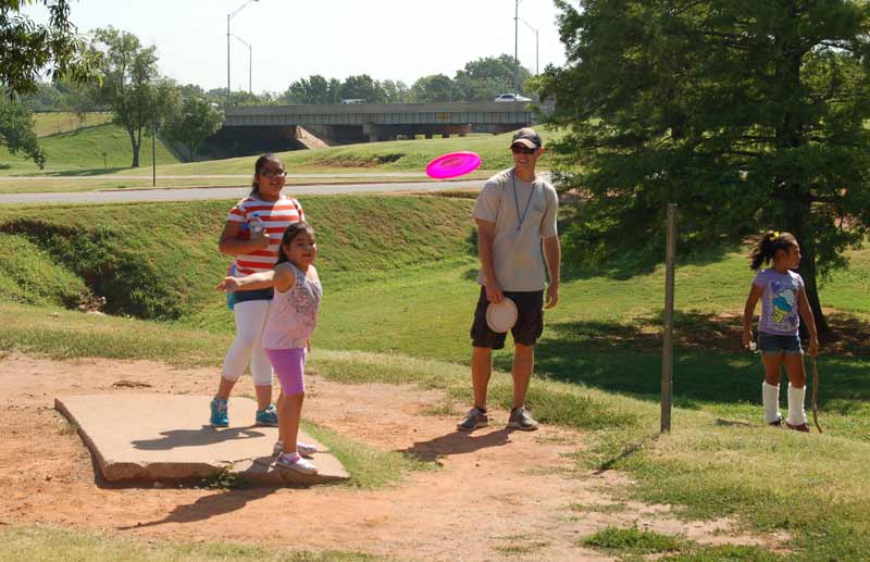 Young players tee off at the Will Rogers Disc Golf Course