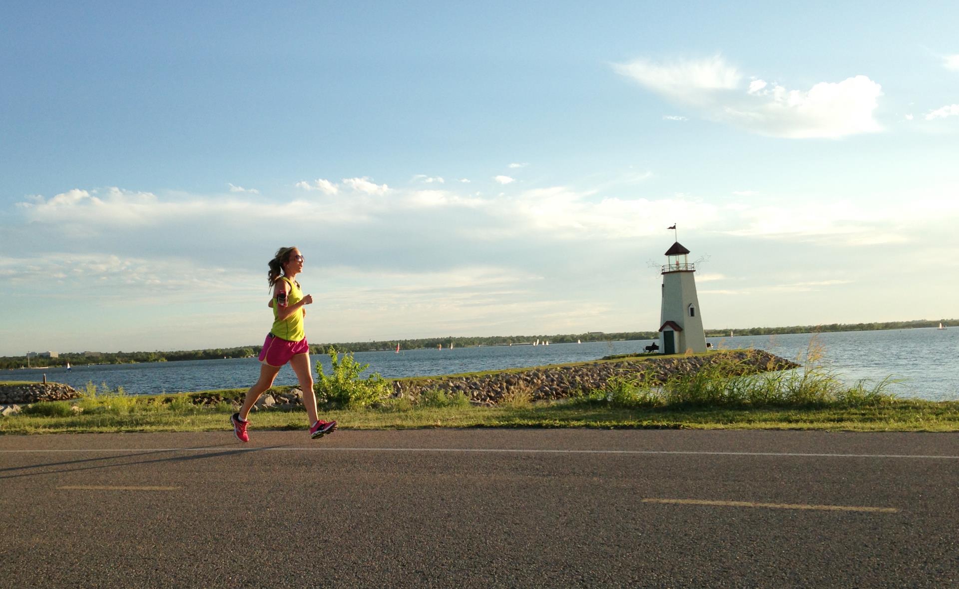 A runner enjoys a lighthouse view on the Burt Cooper Trails